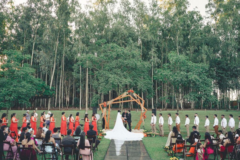 Wedding ceremony under a wooden arch in a forest clearing