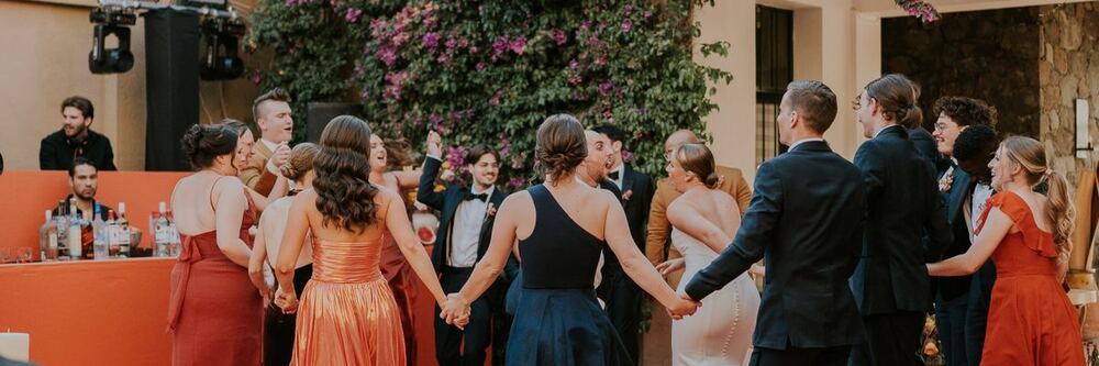 Guests holding hands in a circle on a dance floor